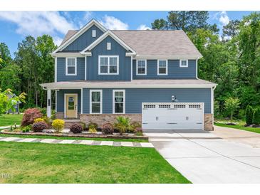 Charming two-story home boasts a manicured lawn and a classic blue exterior at 108 Wilson Farm Ln, Clayton, NC 27527