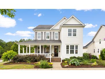 Charming two-story home showcasing a well-manicured lawn and inviting front porch at 1205 Quincy Cottage Rd, Hillsborough, NC 27278
