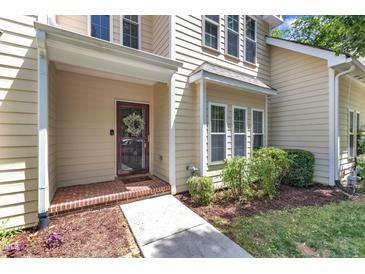 Charming home exterior featuring a brick entryway, decorative wreath, and well-maintained landscaping at 137 Lanigan Pl, Cary, NC 27513