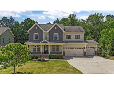 Charming two-story home with a beautifully landscaped front yard and three-car garage at 3122 Jones Lake Rd, Fuquay Varina, NC 27526