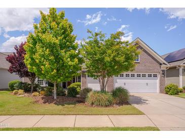 Charming brick home with well-maintained landscaping, lush trees, and a two-car garage at 316 Ibis Ln, Durham, NC 27703