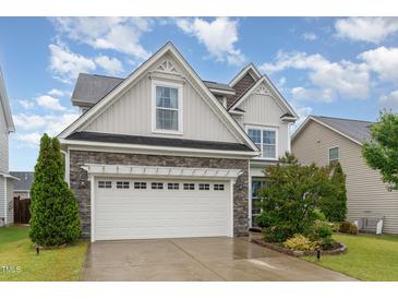 Charming home with a stone facade and a two-car garage, complemented by a well-manicured lawn at 3904 Freemark Ln, Fuquay Varina, NC 27526