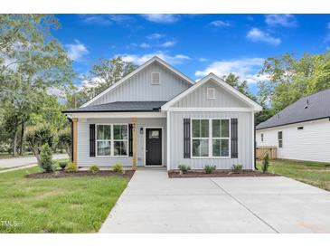 Charming one-story home featuring black shutters, craftsman columns, and a well-manicured lawn at 401 N Raiford St, Selma, NC 27576