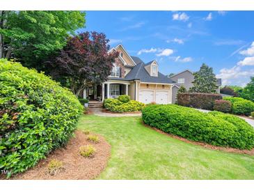 Beautiful two-story home featuring a well-manicured lawn, mature trees, and a two-car garage at 404 Brightling Way, Holly Springs, NC 27540