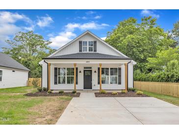 Charming white cottage-style home with black shutters, wood columns, and well-manicured lawn at 405 N Raiford St, Selma, NC 27576