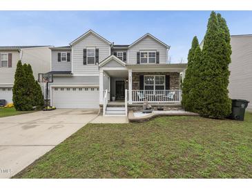 Charming two-story home featuring a covered porch, two-car garage and manicured lawn at 4621 Youngsbury Ct, Raleigh, NC 27604