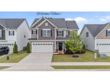 Beautiful two-story home with a well-manicured lawn and a two-car garage at 5292 Goosecross Way, Fuquay Varina, NC 27526