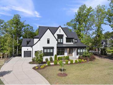 Beautiful two-story home with landscaped front yard, painted white with contrasting black trim and roof at 7417 Dover Hills Dr # 73, Wake Forest, NC 27587