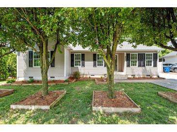 Charming single-story home with a well-maintained front yard, featuring black shutters and lush landscaping at 800 Linens St, Graham, NC 27253