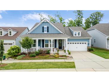 Charming home with a welcoming front porch, well-manicured landscaping, and a convenient two-car garage at 805 Narrative Ln, Durham, NC 27703