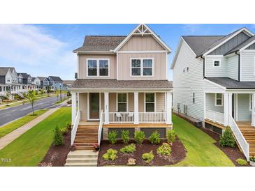 Charming two-story home with a welcoming front porch and landscaped front yard at 825 Abbyberry Dr, Wake Forest, NC 27587