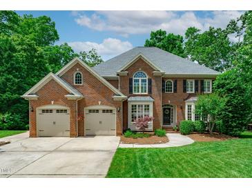 Stately two-story brick home featuring a two-car garage and manicured landscaping at 102 Lions Mouth Ct, Cary, NC 27518