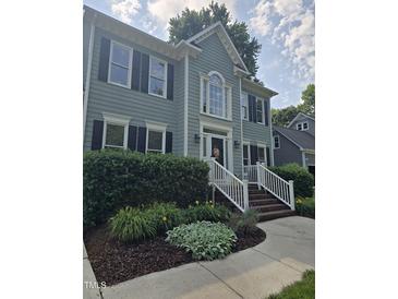 Charming two-story home featuring a manicured lawn, white-trimmed windows, and an inviting entrance with a decorative wreath at 103 Chapelwood Way, Cary, NC 27518