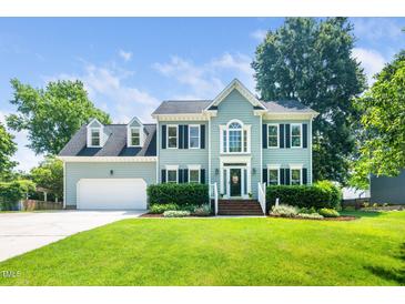 Charming two-story home featuring a manicured lawn, attached garage, and beautiful landscaping at 103 Chapelwood Way, Cary, NC 27518