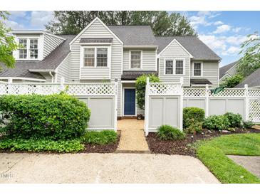 Charming two-story home featuring a well-maintained yard, a welcoming blue front door, and a white picket fence at 113 Spring Cove Dr, Cary, NC 27511