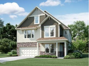 Beautiful two-story home boasts stone accents, siding, covered porch, and an attached garage at 1228 Sparkling Lake Dr # 26, Apex, NC 27523