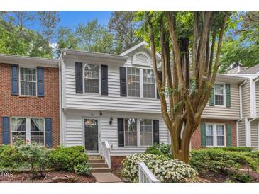 Charming townhouse with white siding, black shutters, and lush landscaping at 134 Riverwalk Cir, Cary, NC 27511