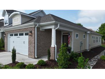 Charming home exterior with a brick accent wall, landscaped yard, and an inviting entrance at 143 Swain St, Clayton, NC 27527