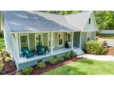 Charming home featuring a welcoming front porch with comfortable seating and well-manicured landscaping at 2409 New Hope Church Rd, Chapel Hill, NC 27514