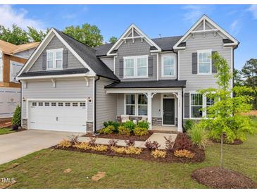 Inviting two-story home showcasing a two-car garage, gray siding, manicured landscaping, and a charming front porch at 3625 Bailey Lake Dr, Fuquay Varina, NC 27526