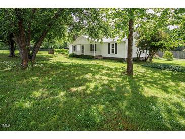 Charming single-story home with a well-maintained lawn and mature trees providing shade at 3627 Nc 57, Hillsborough, NC 27278
