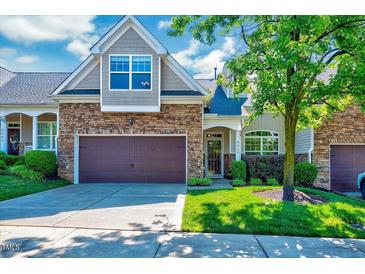Charming brick and siding townhome featuring an attached two-car garage and well-maintained landscaping at 5045 Homeplace Dr, Apex, NC 27539