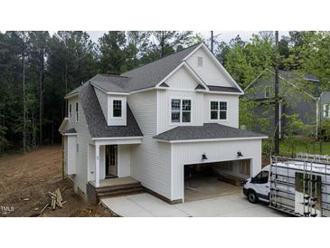 New construction home with white siding, covered garage, and brick-lined front porch at 60 Purslane Dr, Franklinton, NC 27525