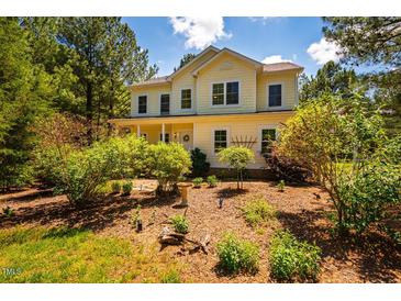Charming two-story home with a well-manicured yard, mature trees, and a welcoming front porch at 815 Solitude Pt, Chapel Hill, NC 27516