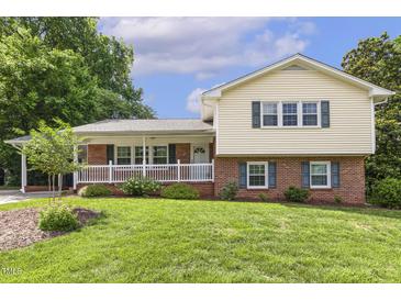 Charming two-story home featuring a brick and siding facade, complemented by a well-manicured lawn at 1000 Winona Rd, Raleigh, NC 27609