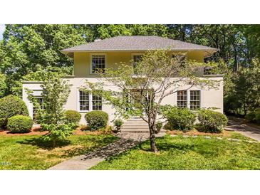 Charming two-story home featuring a well-manicured lawn, mature trees, and a welcoming entrance at 1217 Aycock Ave, Burlington, NC 27215