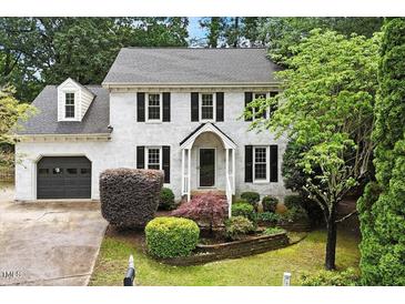 Charming two-story home with a brick facade, black shutters, and well-manicured landscaping at 1312 Stonemoor Ct, Raleigh, NC 27606