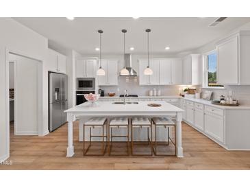 Bright, open kitchen features a large island with seating and stainless steel appliances at 148 Sugar Pine Drive, Franklinton, NC 27525