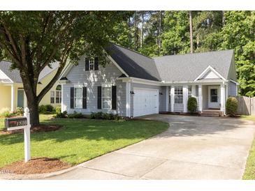Charming home with gray siding, mature tree, and well-manicured lawn and driveway at 1816 Piperwood Ct, Durham, NC 27713