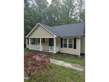 Charming single-story home with a covered front porch and well-maintained landscaping, set among mature trees at 2122 Sterling Creek Ln, Franklinton, NC 27525