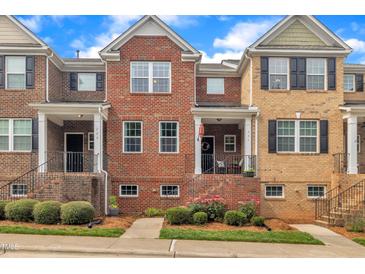 Brick townhome with black shutters and a well-manicured lawn at 231 Grindstone Dr, Apex, NC 27502