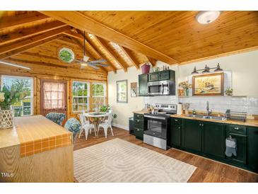 A full view of the kitchen with stainless steel appliances, and a unique wooden ceiling at 2508 Albany St, Durham, NC 27705