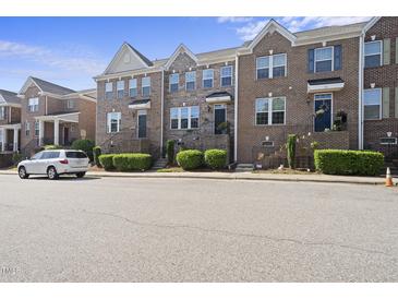 Charming brick townhomes with manicured landscaping and inviting front entrances along quiet street at 309 Old Mill Village Dr, Apex, NC 27502