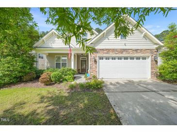 Charming home featuring stone accents, a two-car garage, manicured landscaping, and a welcoming front porch at 320 Trout Valley Rd, Wake Forest, NC 27587
