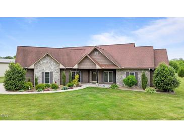 A charming single-story home boasts a well-manicured lawn, stone accents, and a welcoming entrance at 3465 Covington Trl, Mebane, NC 27302