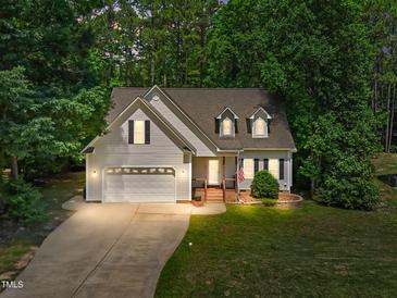 Charming home featuring a manicured lawn, two-car garage, and inviting brick-lined front porch at 347 Manchester Trl, Clayton, NC 27527