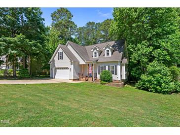 Charming home with a well-manicured lawn, attached garage and mature trees at 347 Manchester Trl, Clayton, NC 27527