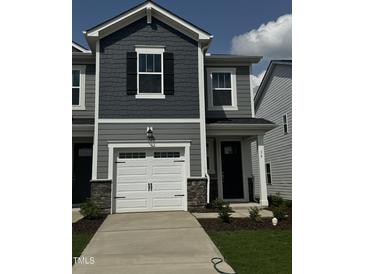 Charming two-story home featuring a white garage door, stone accents, and gray siding at 36 Twin Birch Dr, Angier, NC 27501