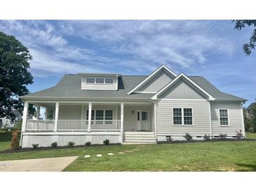 Charming, newly built home with a welcoming front porch and beautifully landscaped front yard at 4016 Berman Edge Rd, Holly Springs, NC 27540