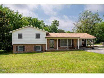 Charming two-story home with a well-manicured lawn and a welcoming front porch at 409 Ivey Rd, Graham, NC 27253