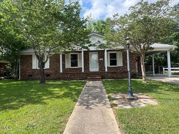 Charming brick home with well-maintained lawn and a covered parking area at 727 Queens Ave, Dunn, NC 28334