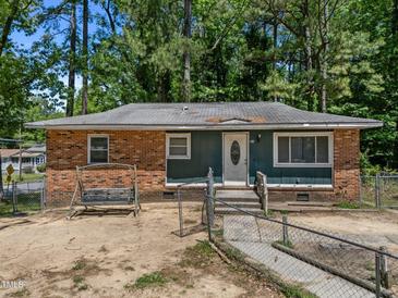 Charming single-story home featuring a brick and siding exterior with a swing, fenced yard and mature trees at 903 Da Vinci St, Durham, NC 27704