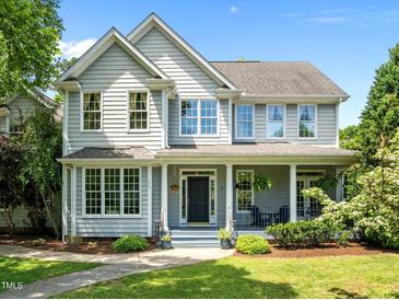 Charming two-story home featuring a welcoming front porch and beautifully landscaped front yard under a clear blue sky at 100 Michaels Way, Chapel Hill, NC 27516