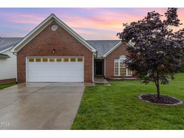 Charming brick home featuring a two-car garage, well-manicured lawn, and attractive landscaping at 103 Rama Ct, Morrisville, NC 27560