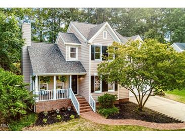 Charming two-story home with landscaped yard, a brick pathway, and a cozy front porch at 107 Ivy Hollow Ct, Morrisville, NC 27560