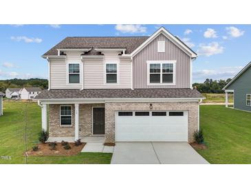 Charming two-story home with a brick facade and a two-car garage at 109 Gladstone Loop, Clayton, NC 27520